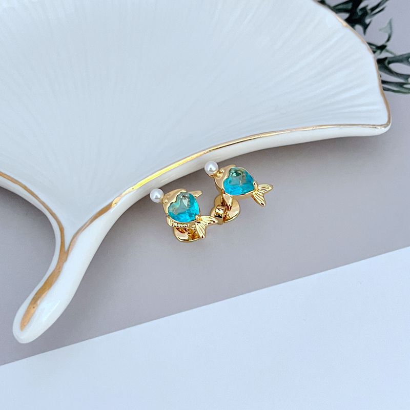 Macro of fish with textured scales and crystal eye. Alt: “Enamel Fish with Crystal Eye Detail – Kate Spade.”