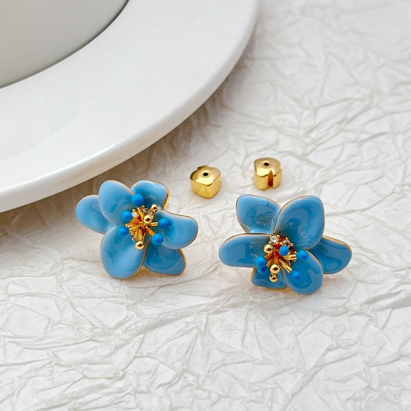 Earrings on a soft cream or dusty rose background, showcasing the pastel enamel petals. Alt: “Kate Spade Pastel Petals Stud Earrings – Floral Enamel Jewelry.”