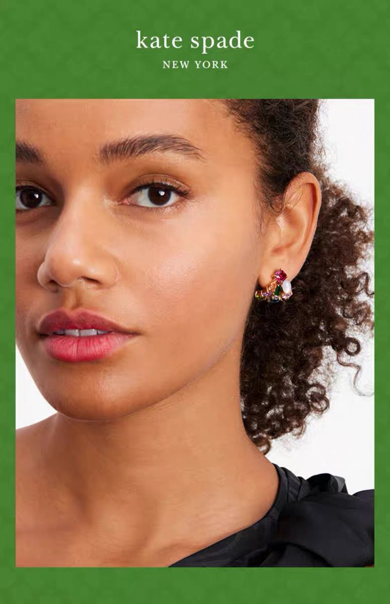 Earrings worn on a model with hair tucked behind the ear, showing their subtle sparkle and sleek fit. Alt: “Everyday Sparkle: Kate Spade Crystal Huggies for Effortless Glam.”