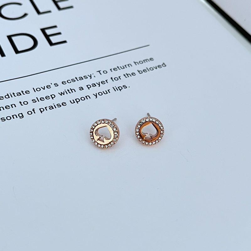 Earrings on a clean white or soft grey background, showcasing the crystal-pavé spade shape. Alt: “Kate Spade Spot The Spade Gold Tone Crystal Stud Earrings – Pavé Spade Jewelry.”