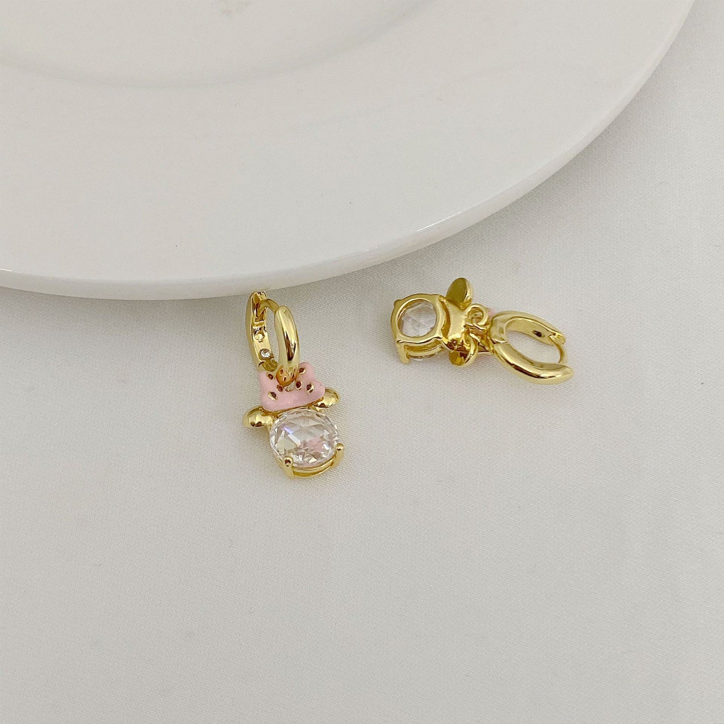 High-definition shot of the pair of earrings laid flat on pure white background, arranged symmetrically.