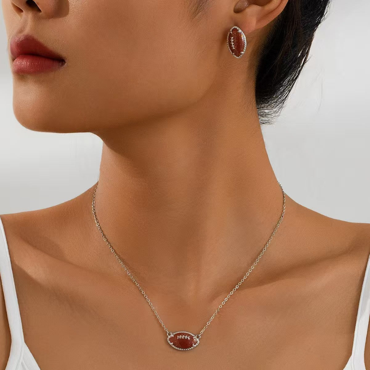 Close-up of a woman wearing a necklace and earrings with a plain background