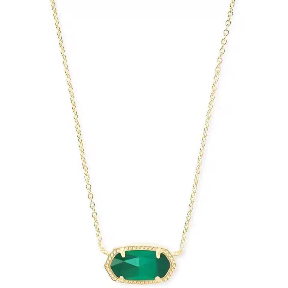 Gold necklace with a green pendant on a white background