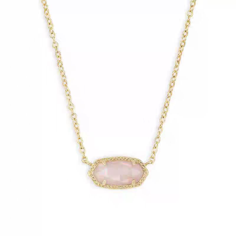Necklace with a pink pendant on a gold chain against a white background
