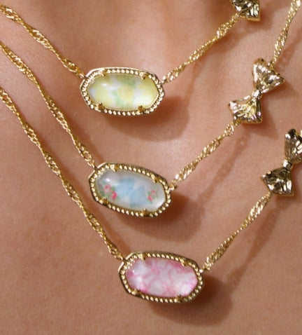 Elegant shot of the necklace on a textured, romantic background (like linen or a floral pattern), highlighting the collaboration and the vibrant turquoise stone.