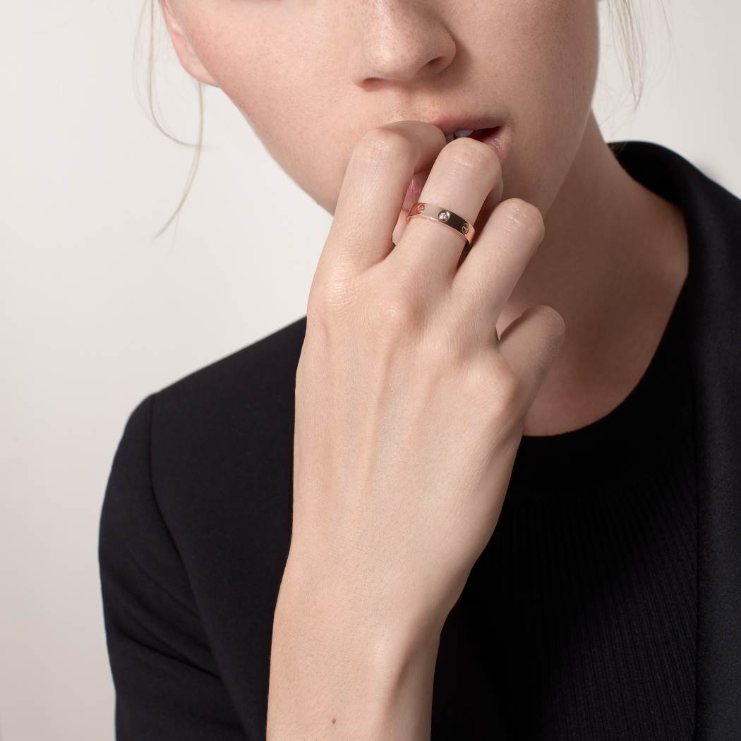 LOVE Ring with Single Diamond | 18K Gold-Plated Sterling SilverPerson wearing a ring on their finger with a plain background