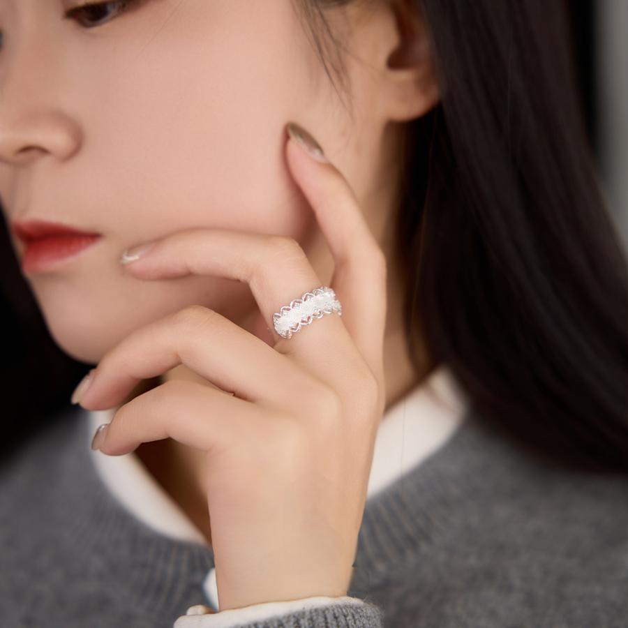 Close-up of a woman wearing a silver ring with a blurred background