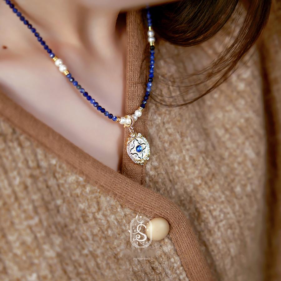 Necklace with a pendant worn by a person, close-up shot.
