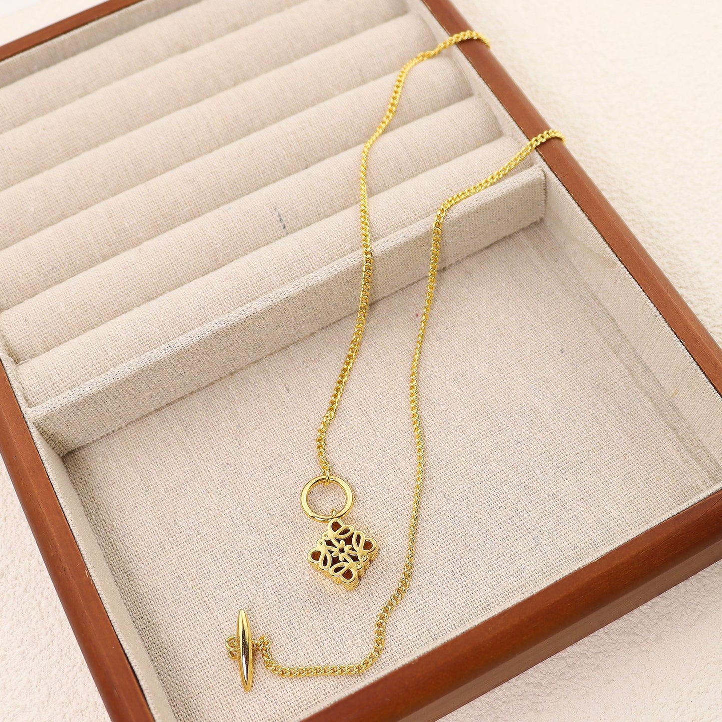 Clean, crisp shot of the necklace laid flat or worn, against a solid neutral background, focusing on the iconic pendant.