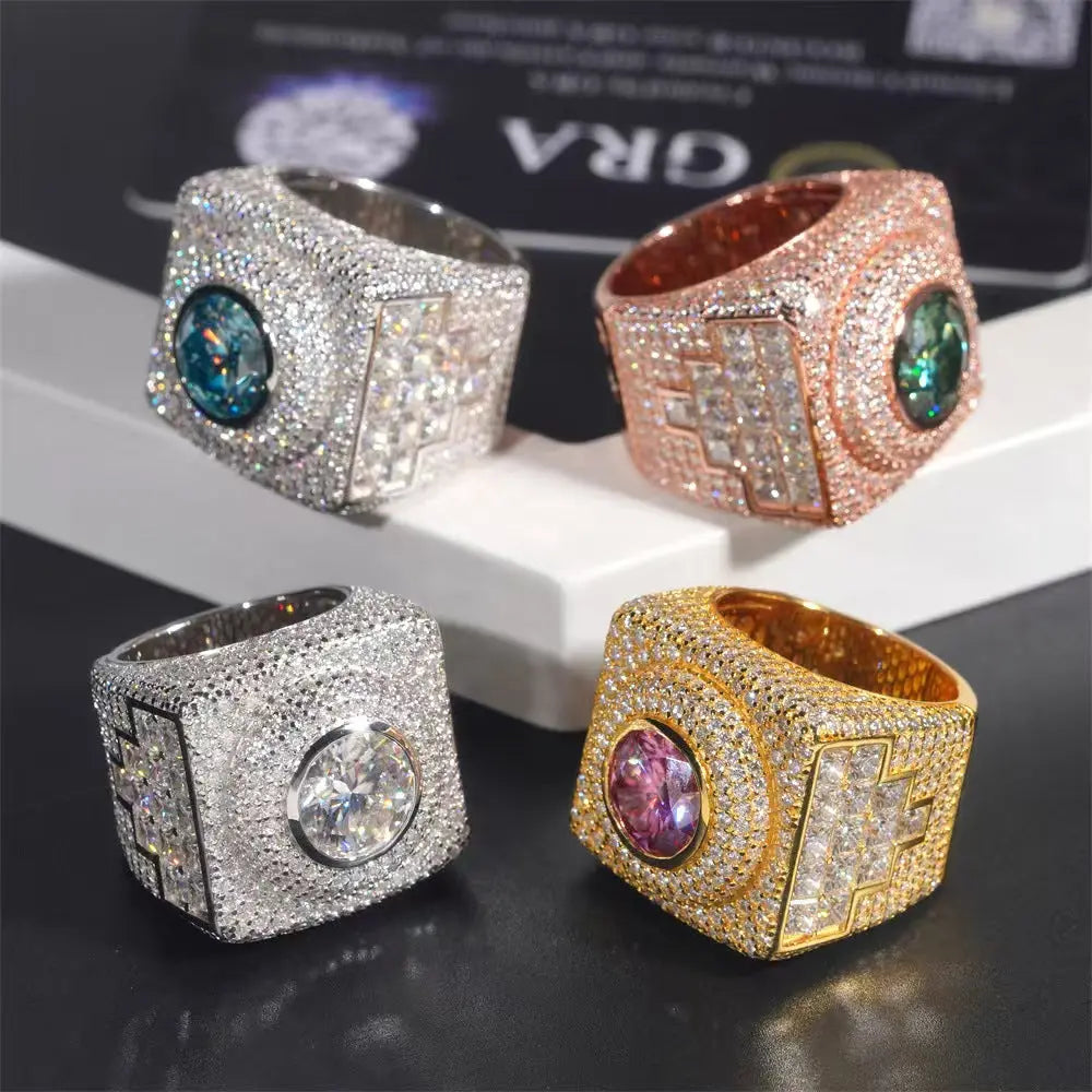 Four diamond-encrusted rings in different colors on a reflective surface.