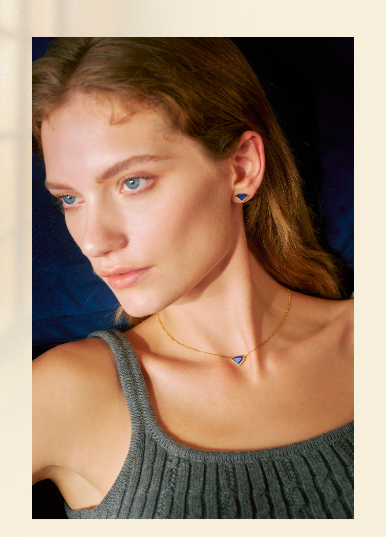 Woman wearing a necklace and earrings with a neutral background