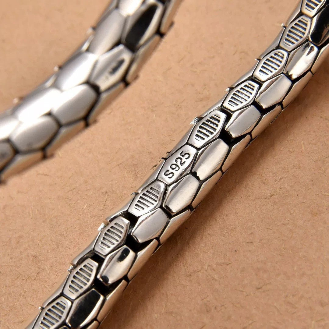 Silver bracelet with textured design on a beige background