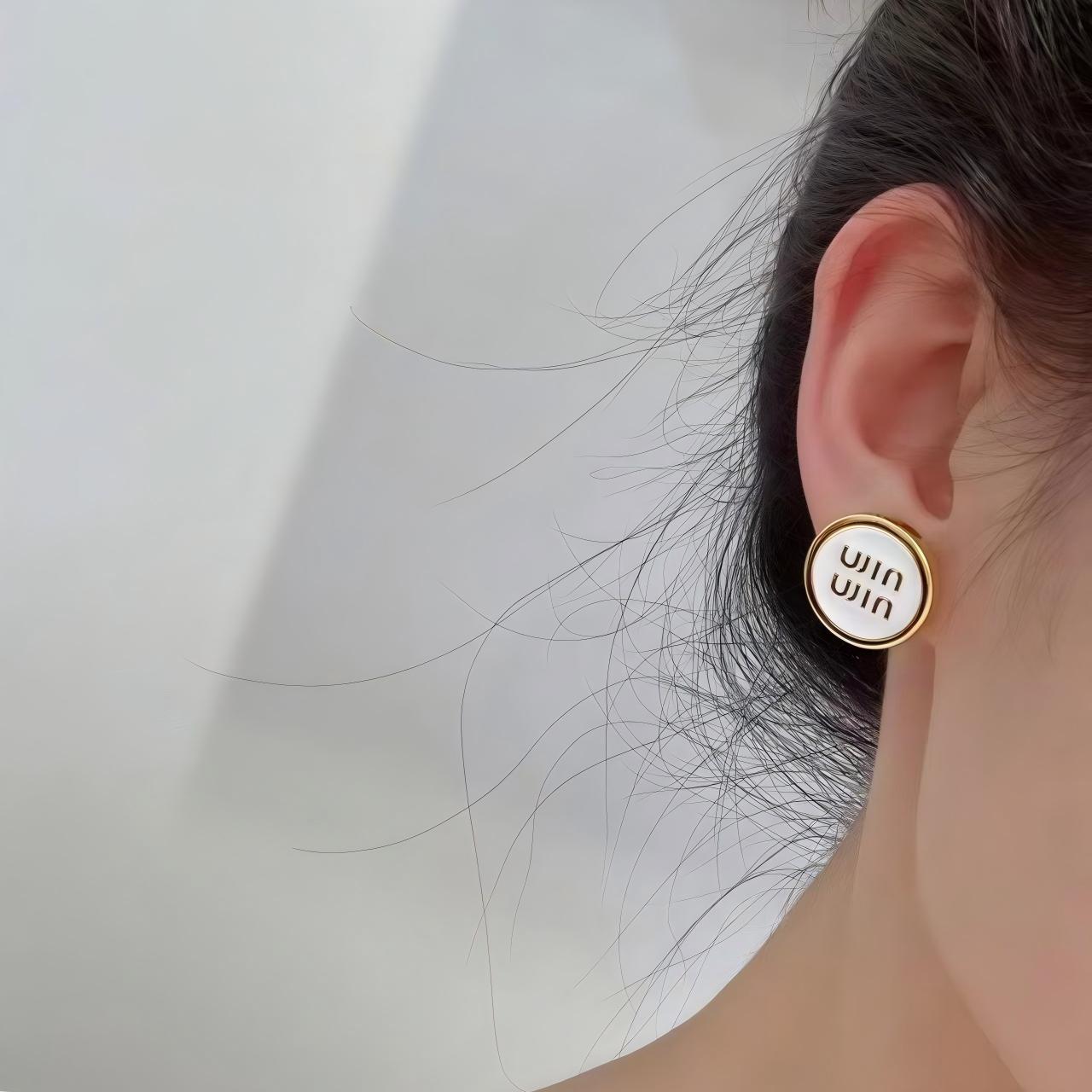 Earrings styled with contemporary outfit demonstrating versatility. Alt text: "Miu Miu Enamel Earrings Styled for Modern Fashion Look"
