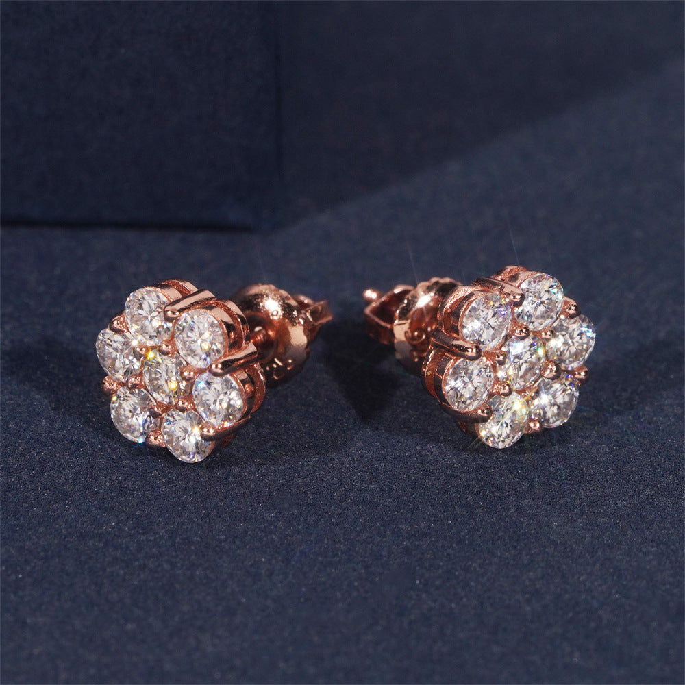 Rose gold earrings with clear gemstones on a dark blue background