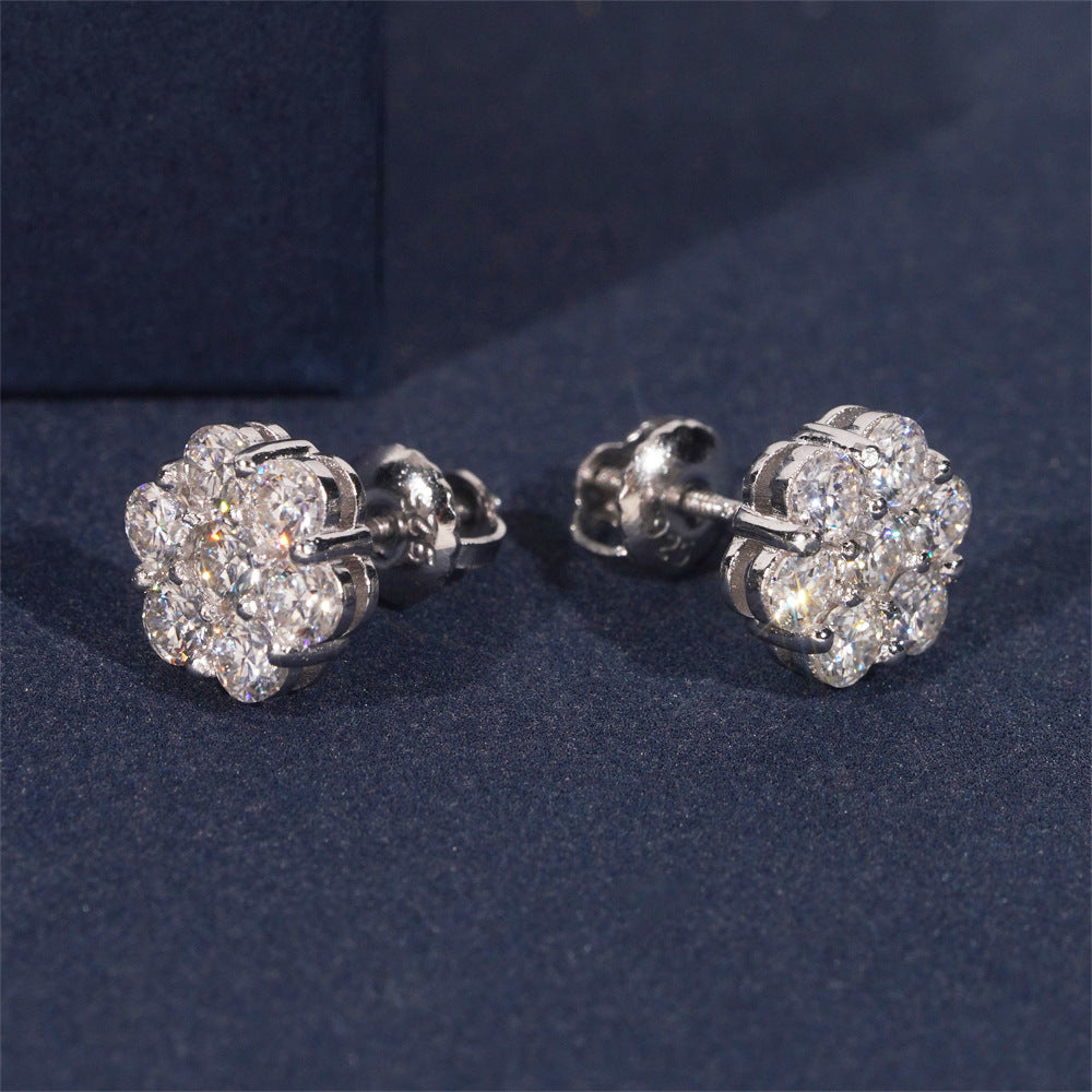 Pair of silver flower-shaped earrings on a dark blue background