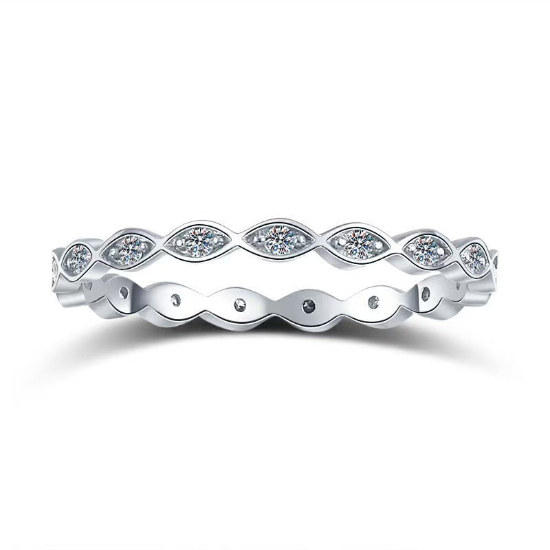 Silver ring with wavy design and embedded diamonds on a white background