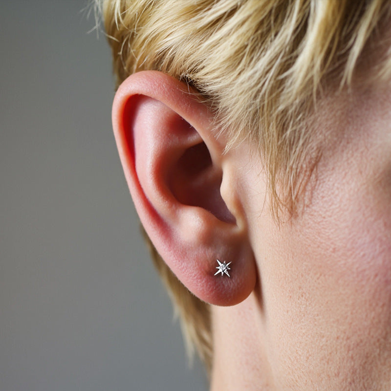 Earrings styled with other minimalist jewelry and a skincare product to emphasize “24/7 wear” concept. Alt: “Effortless Elegance: Styling the North Star Sleeper Earrings.”