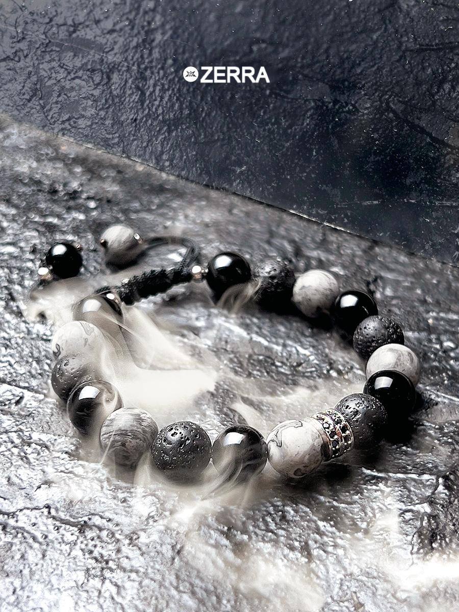 Bracelet with black and white beads on a textured surface, featuring the brand 'Zerra'.