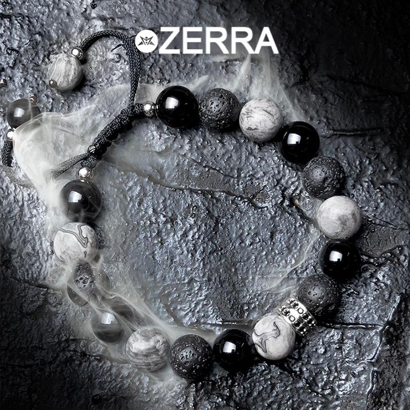 Bracelet with black, white, and gray beads on a textured surface with Zerra branding.