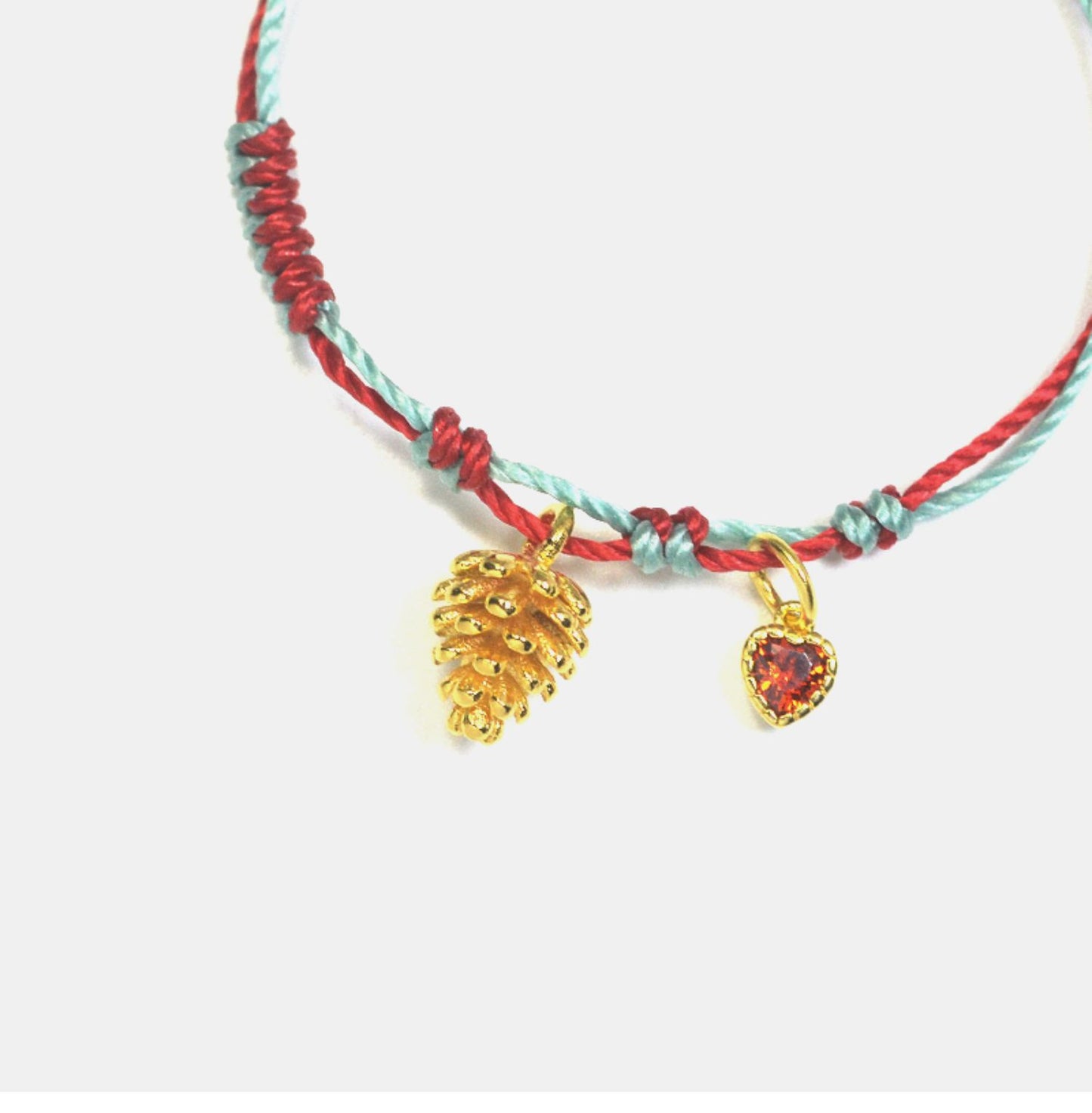 A festive yet refined piece that blends minimalist elegance with warm holiday tones. Handwoven red and green rope embraces a gold-plated 925 silver pinecone charm
