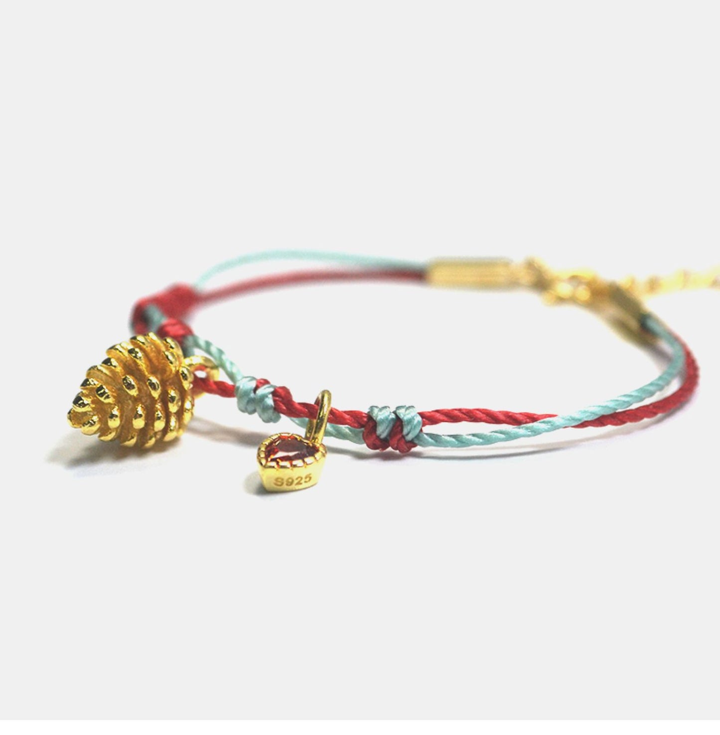A festive yet refined piece that blends minimalist elegance with warm holiday tones. Handwoven red and green rope embraces a gold-plated 925 silver pinecone charm
