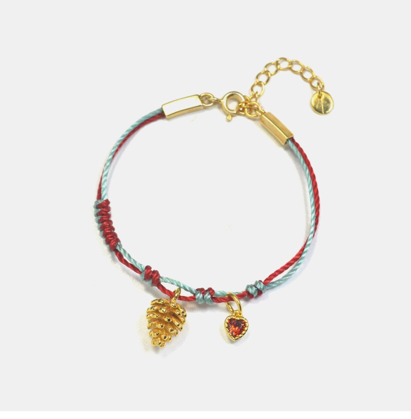 A festive yet refined piece that blends minimalist elegance with warm holiday tones. Handwoven red and green rope embraces a gold-plated 925 silver pinecone charm