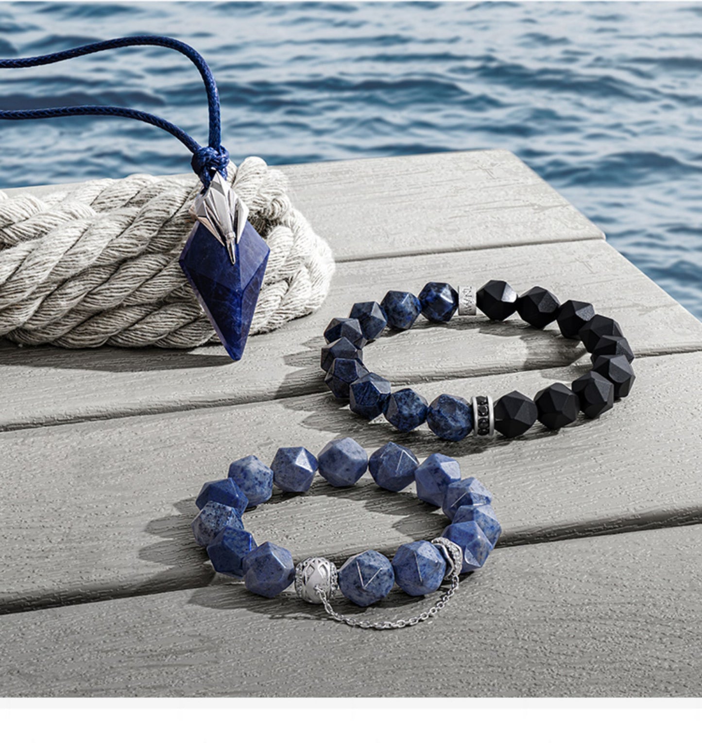 Blue beaded necklace and bracelet on a wooden surface with water in the background