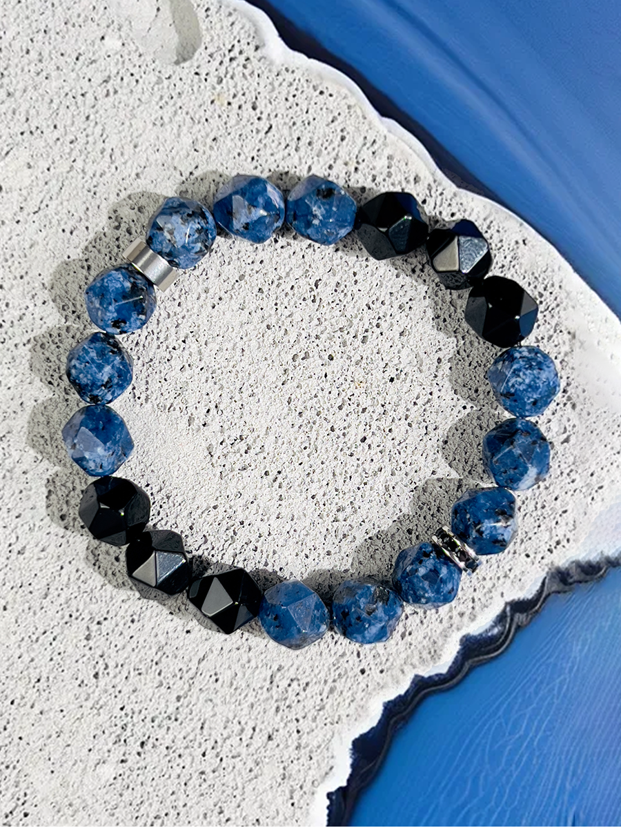 Beaded bracelet with blue and black beads on a textured surface