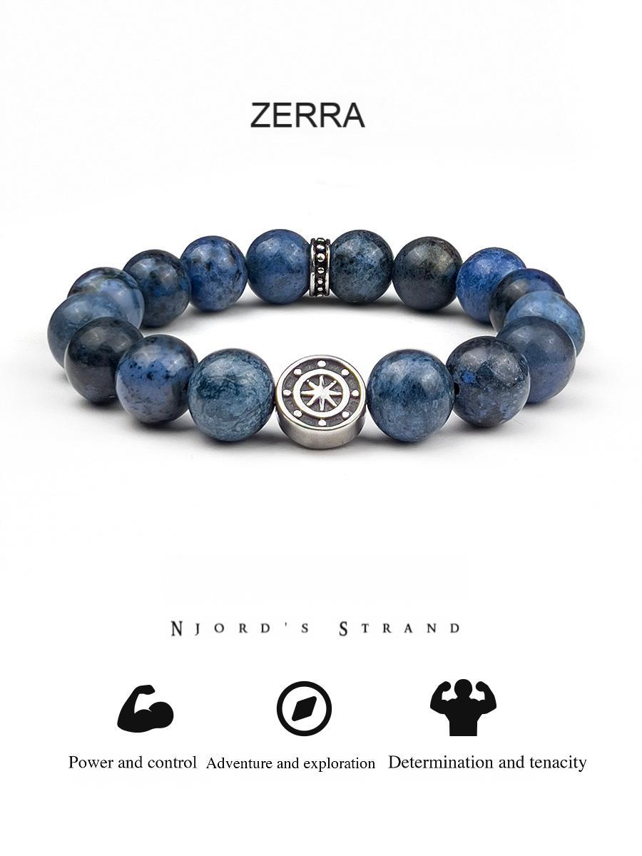 Blue beaded bracelet with a central silver emblem on a white background, featuring the brand 'Zerra'.
