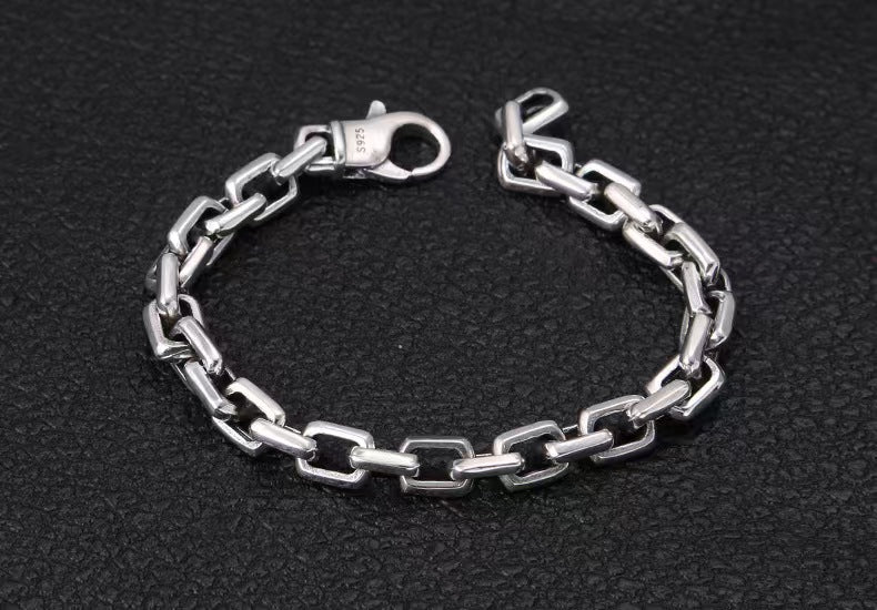 Silver chain bracelet on a black textured background