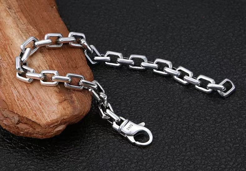 Silver chain with clasp on a dark textured background