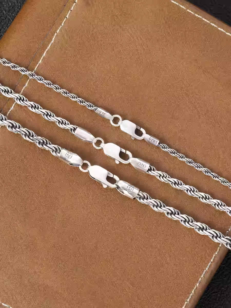 Silver rope chain on a brown leather surface