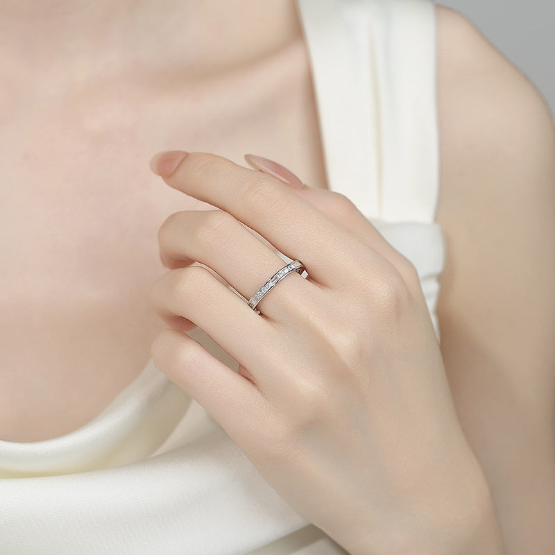 Close-up of a hand wearing a silver ring on a neutral background
