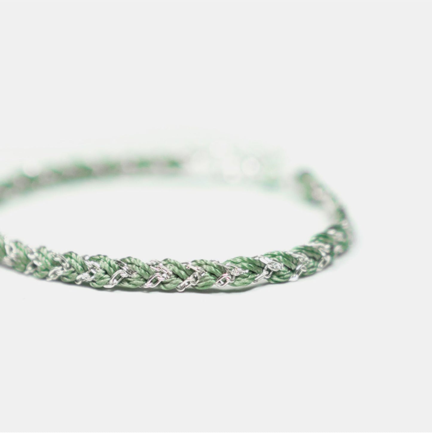Green braided bracelet on a white background