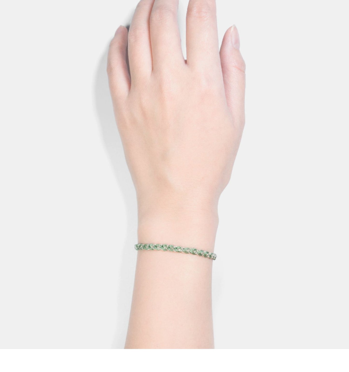 Hand wearing a bracelet on a plain background