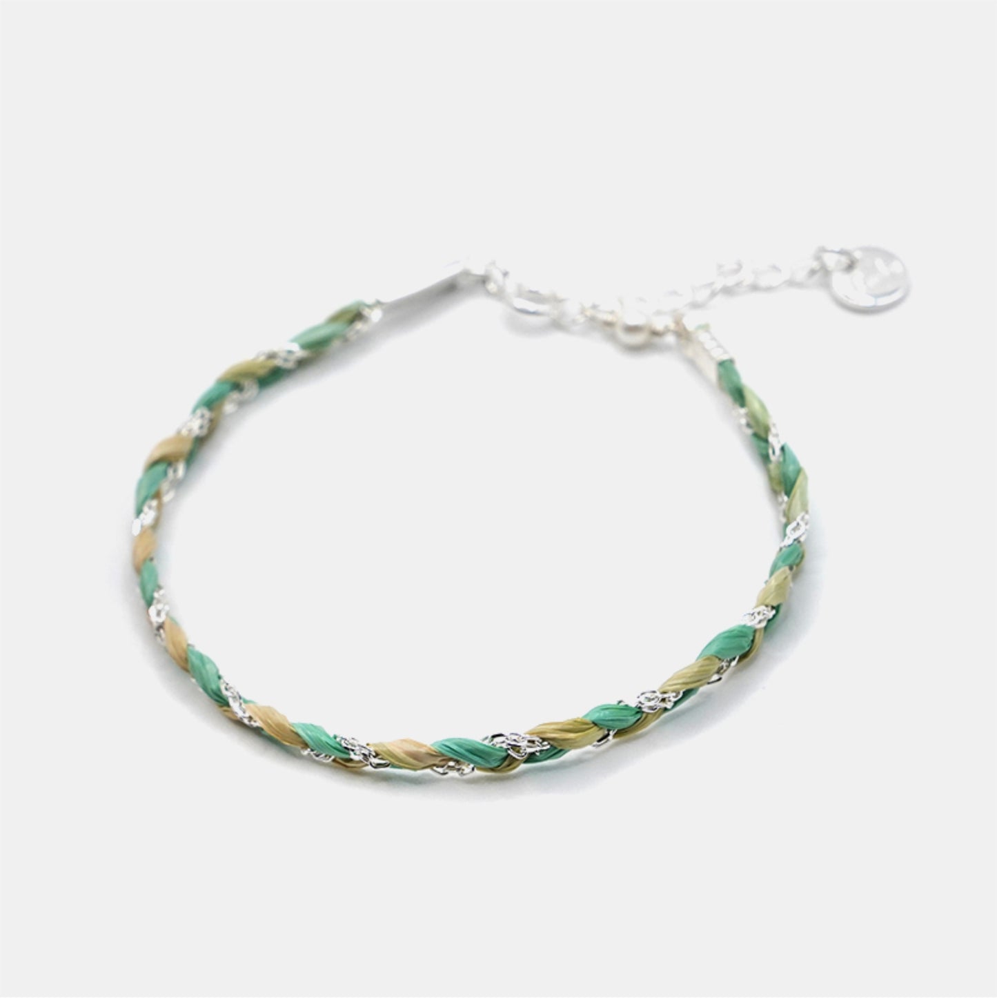 Bracelet with green and gold braided design on a white background