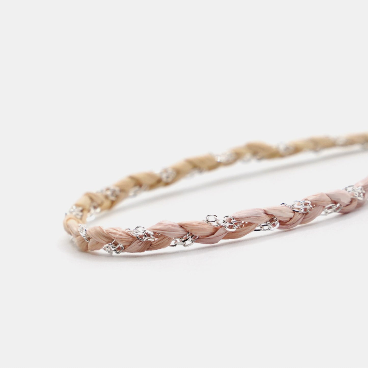 Braided headband with decorative beads on a light background