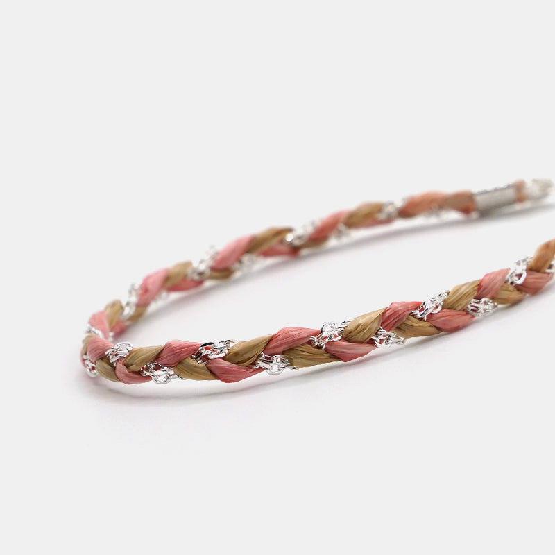Braided hairband with pink and beige strands on a white background