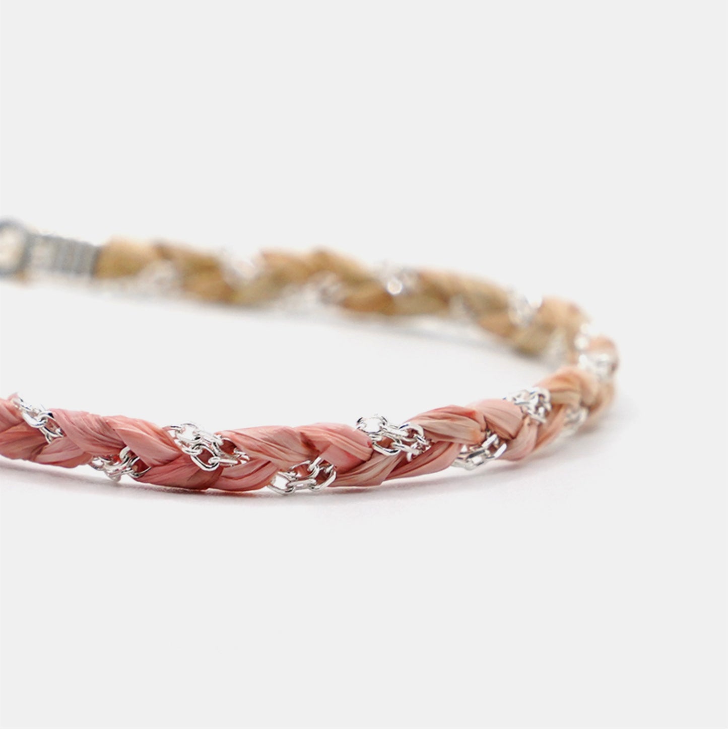 Braided bracelet with pink and beige strands on a white background