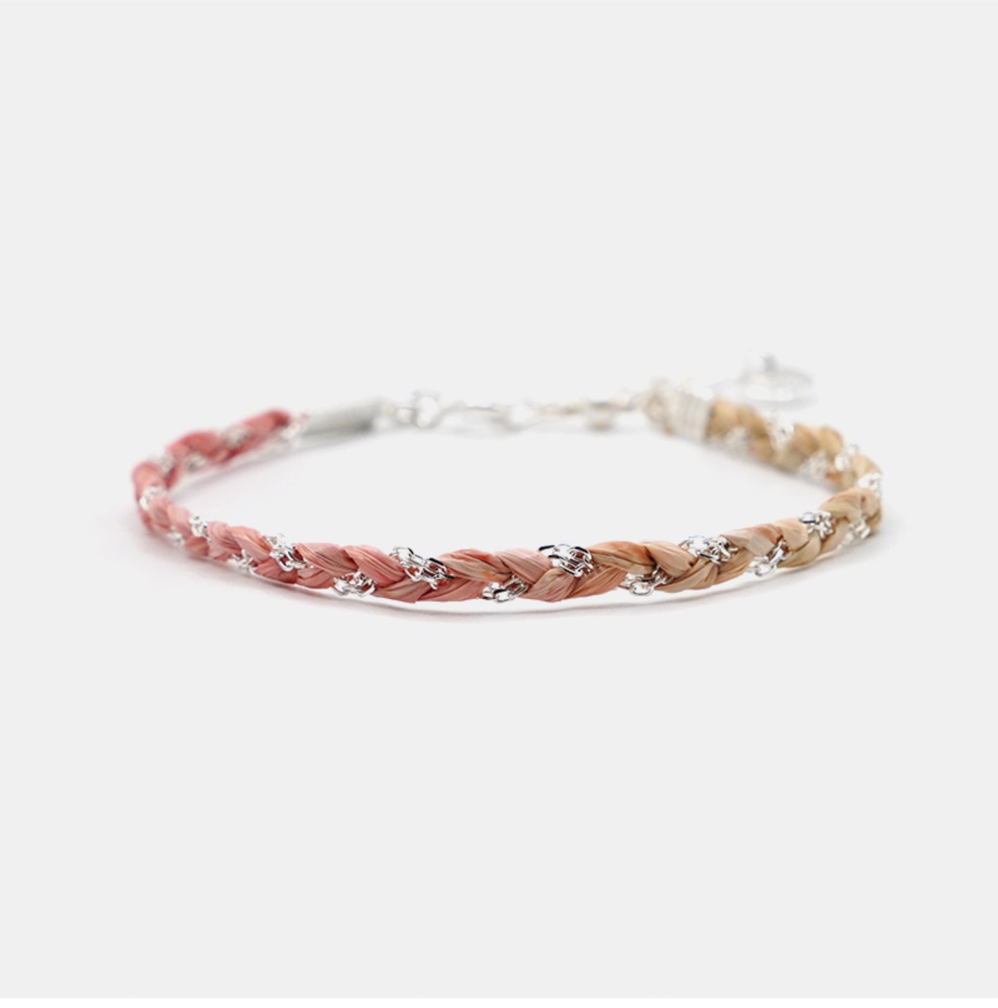 Braided bracelet with pink and beige straps on a white background