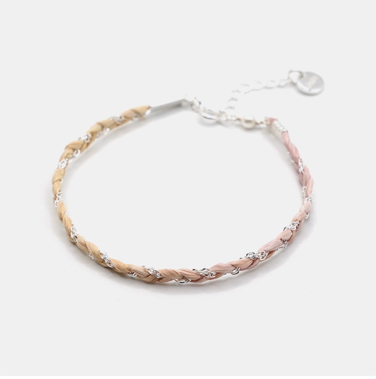 Braided bracelet with pink and silver tones on a white background
