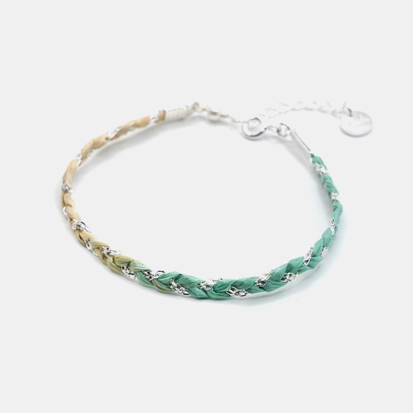 Bracelet with green and beige braided design on a white background