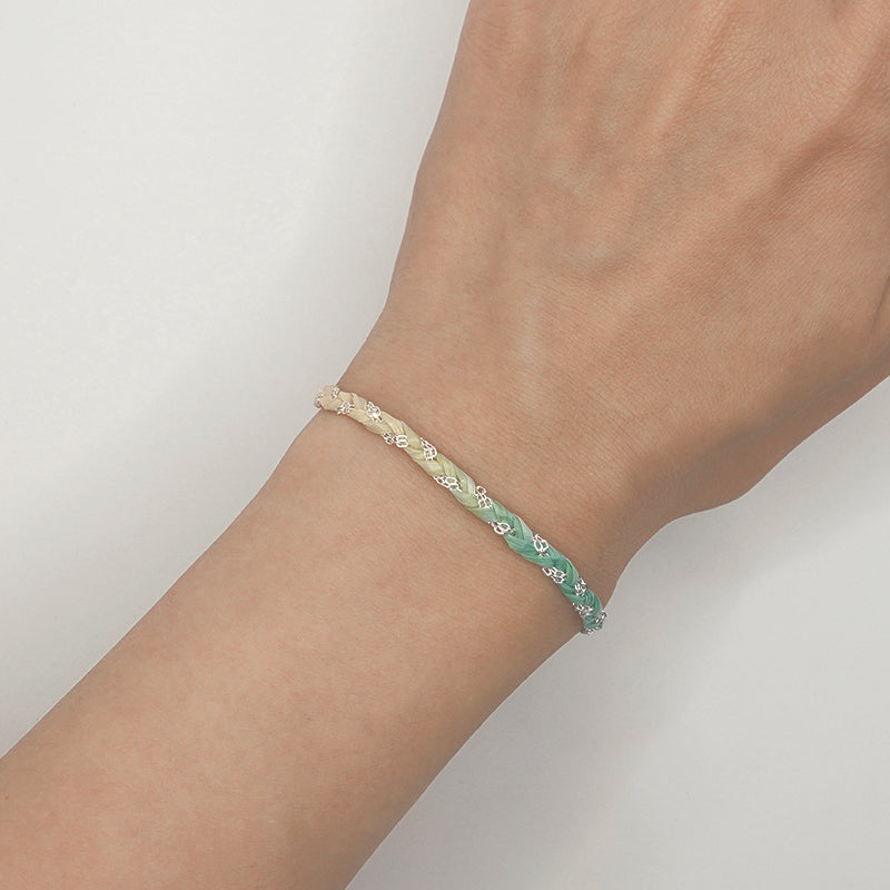 Bracelet with floral pattern on a wrist against a plain background