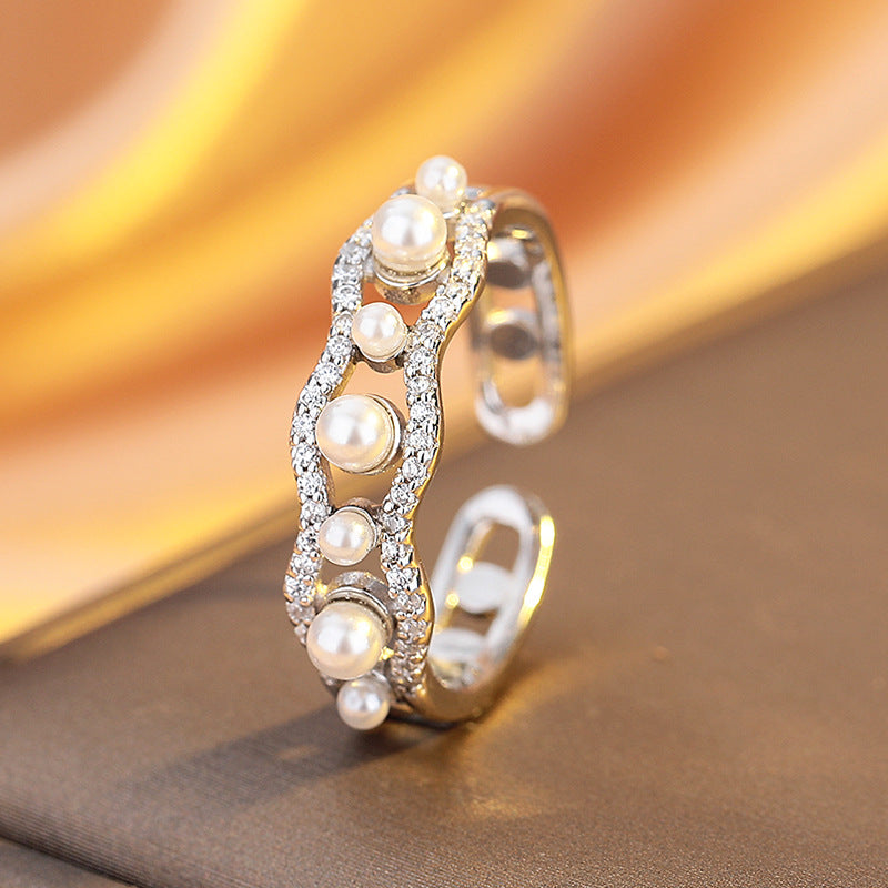 Silver ring with pearls on a brown and gold gradient background