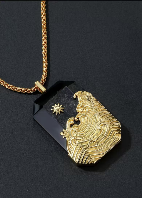 Gold pendant with intricate design on a black background