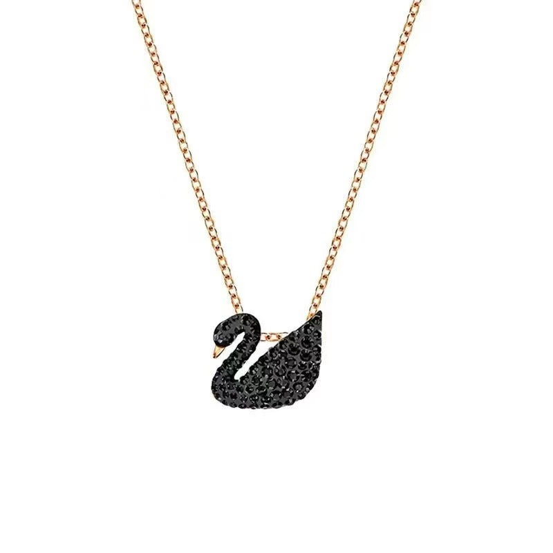 Black swan pendant necklace on a rose gold chain against a white background