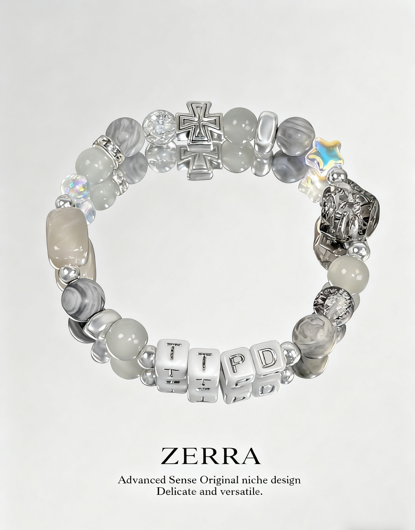 Beaded bracelet with letter beads and a cross charm on a light gray background, featuring the brand 'Zerra'.