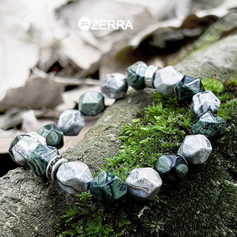 Bracelet with green and white beads on a stone surface with 'Zerra' branding.