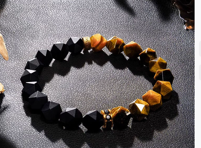 Bracelet with black and yellow beads on a textured surface