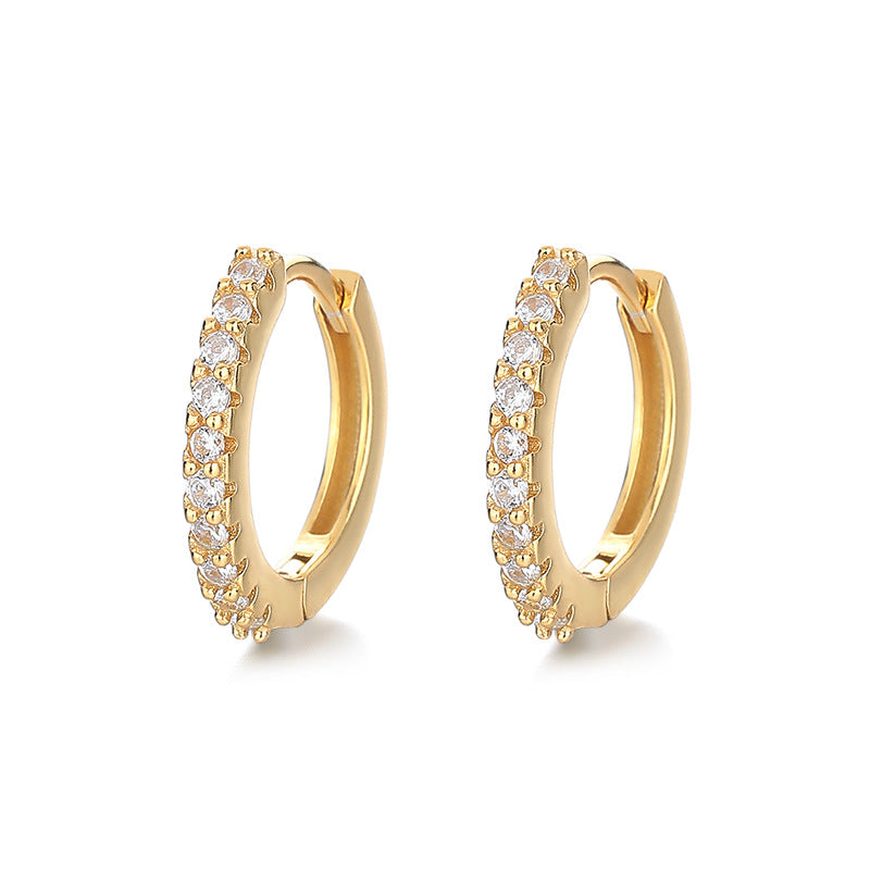 Gold hoop earrings with clear gemstones on a white background
